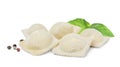 Uncooked ravioli, basil and peppercorns on white background