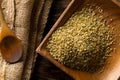 Uncooked, raw freekeh or firik, roasted wheat grain, on wooden plate with wood spoon on brown table background Royalty Free Stock Photo