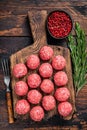 Uncooked Raw meatballs from ground beef and pork meat with rosemary. Dark Wooden background. Top view Royalty Free Stock Photo