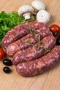 Uncooked raw sausages on wooden board Royalty Free Stock Photo