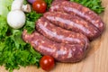 Uncooked raw sausages on wooden board Royalty Free Stock Photo