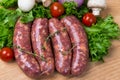 Uncooked raw sausages on wooden board Royalty Free Stock Photo