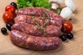 Uncooked raw sausages on wooden board Royalty Free Stock Photo