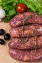 Uncooked raw sausages on wooden board Royalty Free Stock Photo