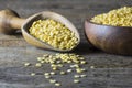 Uncooked raw yellow lentil in wooden shovel and bowl on wooden rustic table Royalty Free Stock Photo