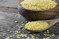 Uncooked raw yellow lentil in wooden spoon and bowl on wooden rustic table Royalty Free Stock Photo