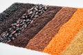 Uncooked red lentil, buckwheat, quinoa, black beans and rice isolated on white.