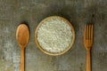 uncooked rice or dry rice. raw rice in wooden bowl with wooden spoon and fork Royalty Free Stock Photo