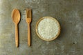 uncooked rice or dry rice. raw rice in wooden bowl with wooden spoon and fork Royalty Free Stock Photo
