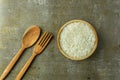 uncooked rice or dry rice. raw rice in wooden bowl with wooden spoon and fork Royalty Free Stock Photo