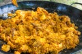 Uncooked rice mixed with deep fried chicken and rabbit meat tomato sauce and olive oil. Process of cooking paella or jambalaya