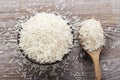 Uncooked rice in a wooden spoon and a clay plate Royalty Free Stock Photo