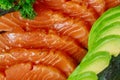Uncooked salmon fish fillet with avocado, on marble plate, top view ingredients ready to eat Royalty Free Stock Photo