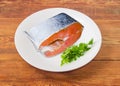 Uncooked salmon steak with parsley on a white dish Royalty Free Stock Photo