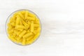 Uncooked short pasta tubes, elicoidali in a glass bowl, top view Royalty Free Stock Photo