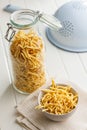 Uncooked spaetzle pasta in jar on kitchen table Royalty Free Stock Photo