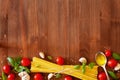 Uncooked spaghetti, cherry tomato, basil, garlic and olive oil, ingredients for cooking pasta, food background Royalty Free Stock Photo