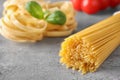 Uncooked spaghetti on grey table, space for text. Italian pasta