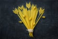 Uncooked Spaghetti Penne Pasta Arranged in Composition of Wheat Ears Bouquet on Black Stone Background. Menu Poster Template