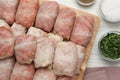 Uncooked stuffed cabbage rolls on white wooden table, flat lay Royalty Free Stock Photo