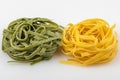 Uncooked tagliatelle pasta, green and yellow, two nests Royalty Free Stock Photo