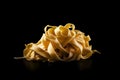 Uncooked tagliatelle pasta isolated on black background. AI generated