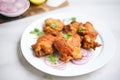 uncooked tandoori chicken thighs on a white plate