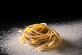 Uncooked traditional hand - rolled durum wheat pasta Pici of Tuscany, black background