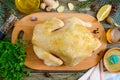 Uncooked turkey on the wooden table with ingredients for marinade.