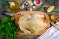 Uncooked turkey on the wooden table with ingredients for marinade