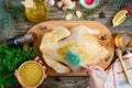 Uncooked turkey on the wooden table with ingredients for marinade