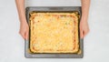 Uncooked vegetarian pizza on baking pan in woman`s hands, close up view from above Royalty Free Stock Photo
