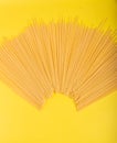 Uncooked yellow long spaghetti on a rustic background. Yellow italian pasta. Long spaghetti