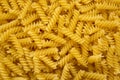 Uncooked Yellow Organic Rotini Pasta, view from above. Flat lay, top view, overhead. Closeup