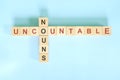 Uncountable nouns concept in English grammar noun education. Wooden block crossword puzzle flat lay in blue background. Royalty Free Stock Photo