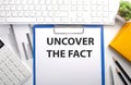 UNCOVER THE FACT written on the paper with keyboard, chart, calculator and notebook Royalty Free Stock Photo