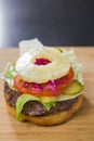 Uncovered burger with pineapple and tomato on the table