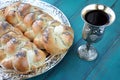 Uncovered challah bread and Kiddush wine cup