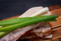 Uncured Apple Smoked Bacon garnished with Green Onion Scallions on natural wooden cutting board Royalty Free Stock Photo
