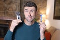 Undecided man holding shaving tools Royalty Free Stock Photo