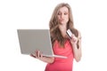 Undecided woman holding credit card and a laptop