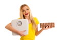 Undecided woman holding scale and chocolate uncertain wether to