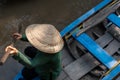 An undefined boatwoman, rowing a wooden boat. Vietnam