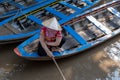 An undefined boatwoman, rowing a wooden boat. Vietnam