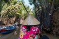 An undefined boatwoman, rowing a wooden boat. Vietnam