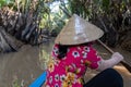 An undefined boatwoman, rowing a wooden boat. Vietnam