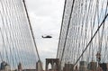 Undefined helicopter flying over Brooklyn Bridge in New York City