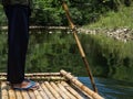 Undefined man drives a makeshift raft sailing along a river in the jungle Royalty Free Stock Photo