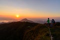 Undefined traveler standing on high mountain in sunset time