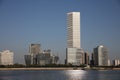 Under a blue sky, a line of modern housing buildings, towering white, stand by the riverside of huangpu River in Shanghai